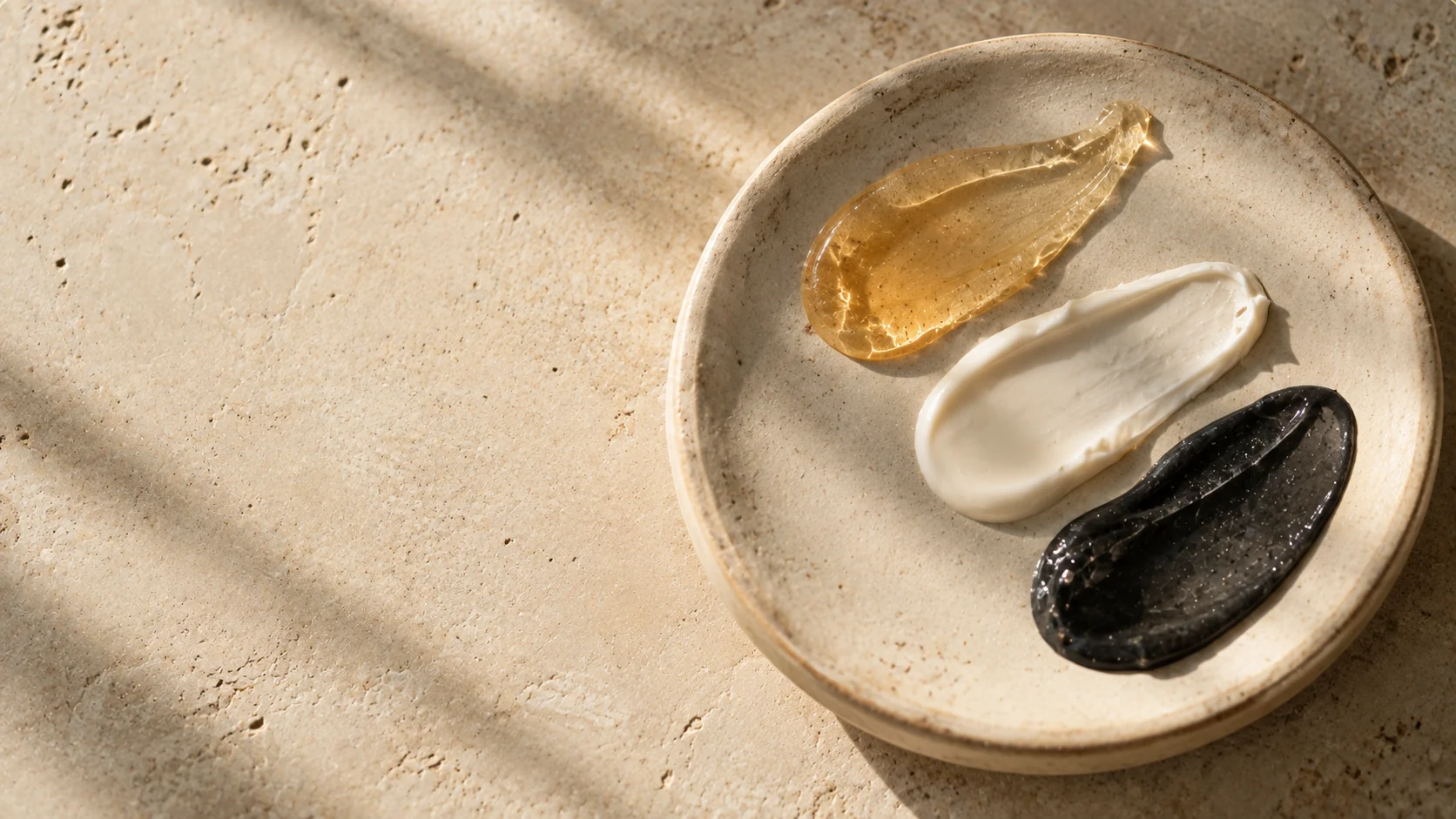 Three contrasting skincare texture studies on pale stone