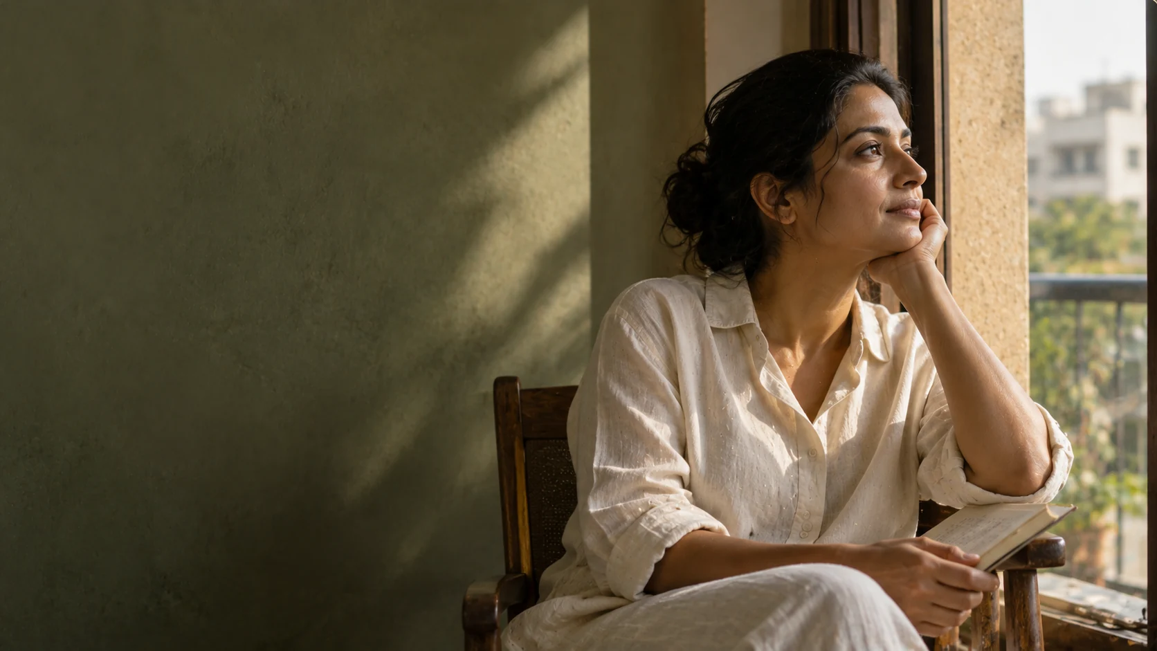 A woman pausing beside a window at the start of her day